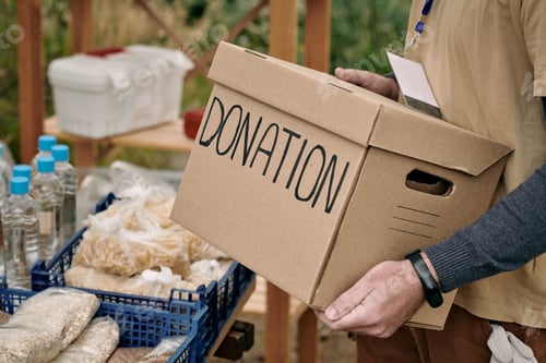 Preview: Male volunteer holding packed donation box