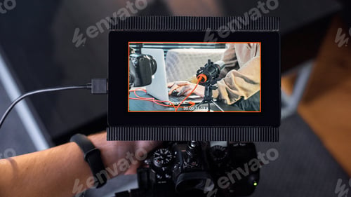 Preview: Professional photographer holding a camera with external display