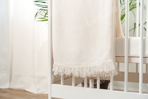 Preview: Muslin baby blanket hanging on child's bed in nursing room