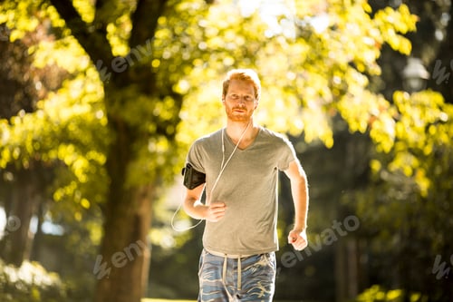 Preview: Young man running in the autumn park