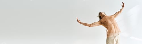 Preview: Young dancer with curly hair expressing joy in a dance studio against a grey backdrop