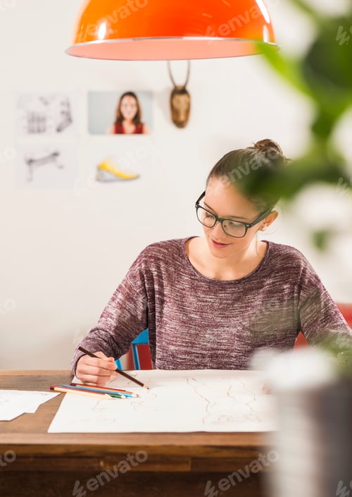 Preview: Young woman drawing at home