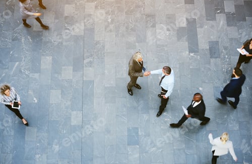 Preview: Adult office workers shaking hands in crowded hall