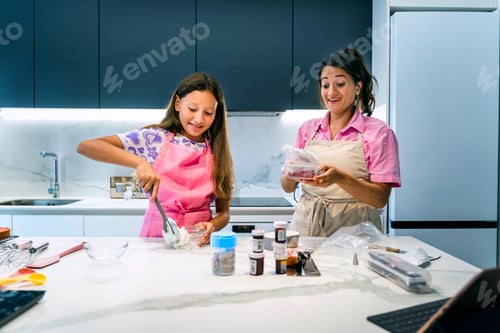 Preview: Mother and daughter cooking happily and laughing in the kitchen.