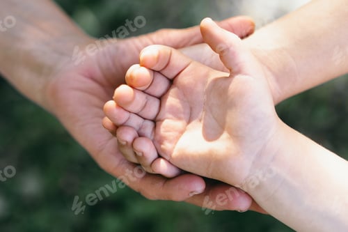 Preview: Grandmother and child hand holds a heart. Concept protecting, friendship, togetherness