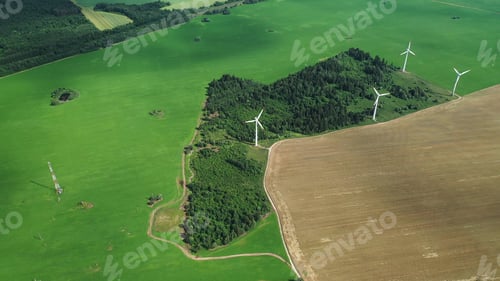 Preview: Windmills in summer in a green field.large windmills standing in a field near the forest.Europe