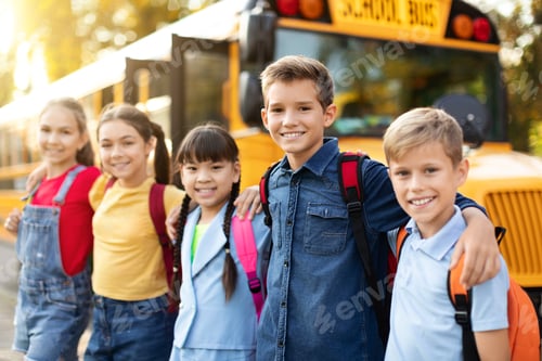 Preview: Happy Multiethnic Children Posing Outdoors Near School Bus, Embracing And Smiling