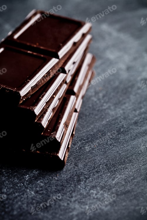 Preview: Dark chocolate bar pieces closeup. Sweet food photo concept.