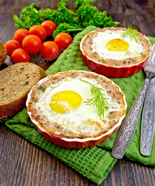 Preview: Tartlet meat with egg in pan on dark board