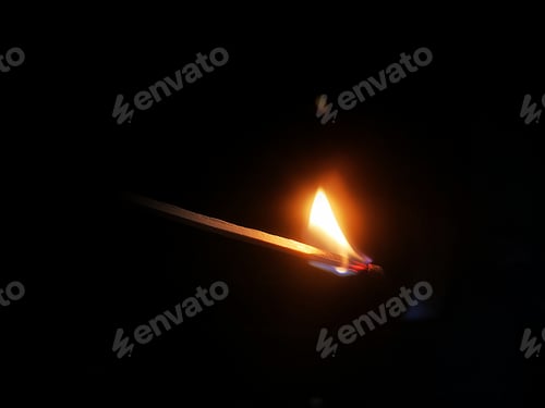 Preview: a single match stick on fire in front of black background