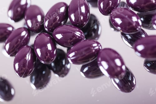Preview: capsules purple pills closeup on mirror surface