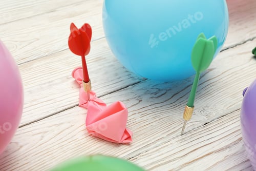 Preview: Throwing wires into balloons, on a light, wooden background.