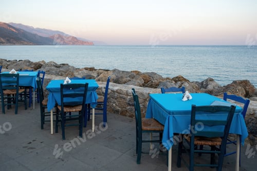 Preview: Empty beach tavern restaurant at Paleochora town, Crete island Greece. Rocky landscape, sea, sky.