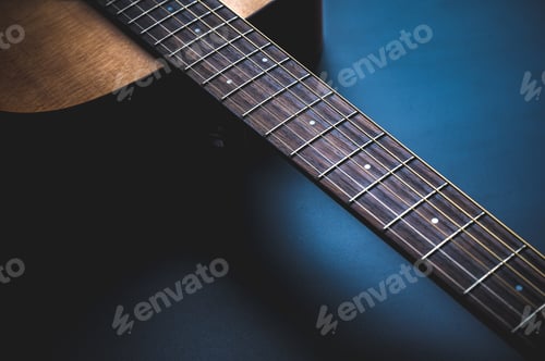 Preview: Acoustic guitar, music instrument resting against a dark black background