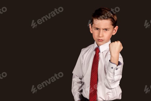 Preview: Serious boy in shirt and tie shows fist to revenge or threatening with angry look