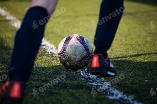 Preview: Football soccer player ready to kick the football ball, in green field on a sunny day.