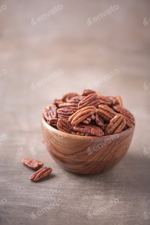 Preview: Pecan nuts in wooden bowl on wood textured background. Copy space. Superfood, vegan, vegetarian food