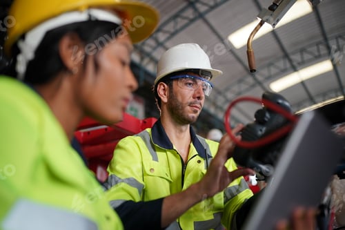Preview: Robotics engineer working on maintenance of robotic arm in factory warehouse. Business technology.