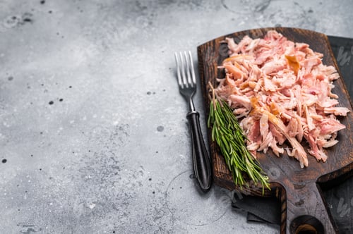 Preview: Shredded or Pulled Chicken meat on wooden board. grey background. top view