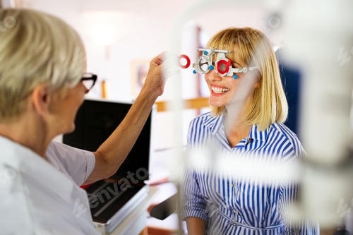 Preview: Young woman taking an eyesight test examination at an optician clinic