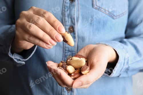 Preview: Woman holding delicious Brazil nuts, closeup view