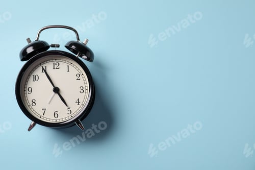 Preview: Black alarm clock on light blue background, top view. Space for text