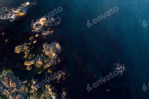 Preview: Aerial shot of a picturesque beach, showing the ocean's turquoise waters and rocks