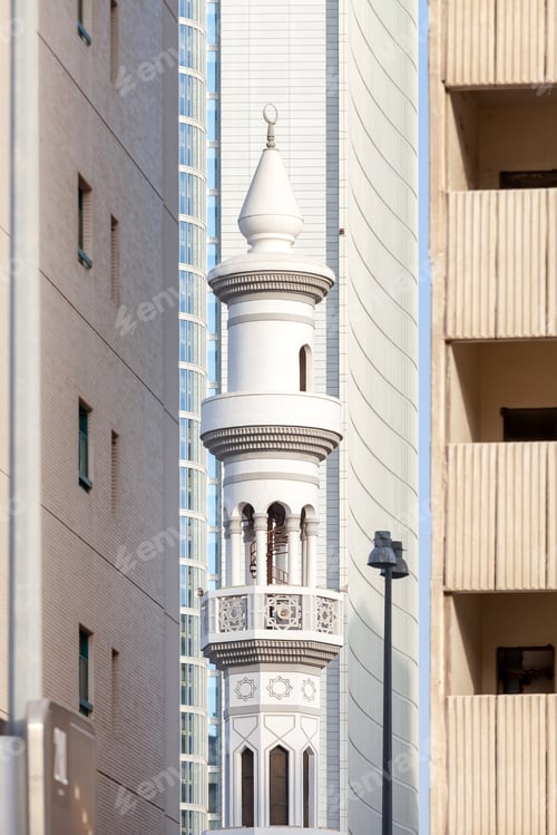 Aperçu: Minaret of the mosque in Abu Dhabi surrounded by modern high rise buildings