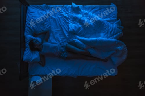 Preview: The woman sleeping on the bed. Evening night time. View from above.