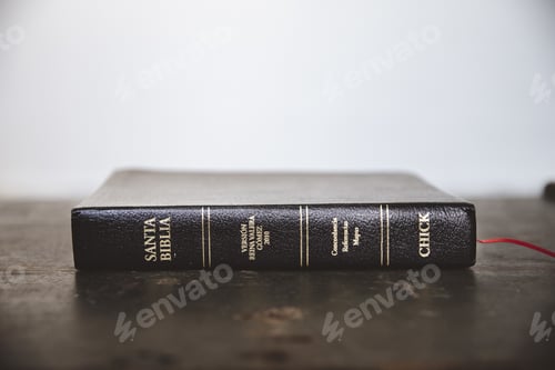 Preview: Closeup shot of the bible on a wooden surface with a blurred background