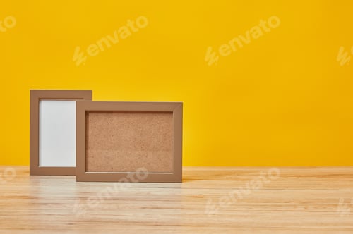 Preview: Empty photo frames at wooden table isolated on yellow