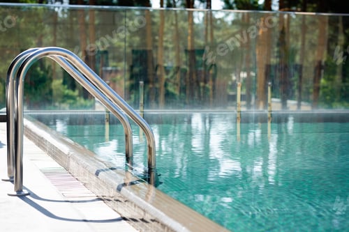 Preview: transparent swimming pool with railings on resort during daytime