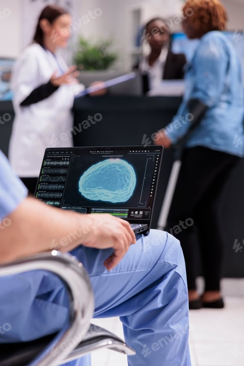 Preview: Male nurse analyzing brain animation on laptop