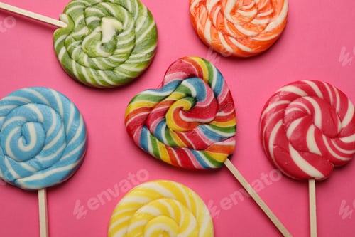 Preview: Tasty lollipops on bright pink background, flat lay