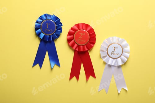 Preview: Different award ribbons on yellow background, flat lay