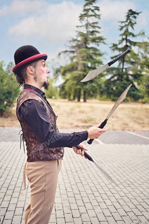 Preview: Man juggling knives in park