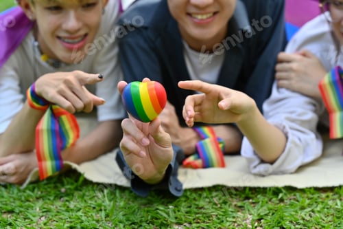 Preview: Group of young activist with pride rainbow flag in their backs supporting LGBTQ community.