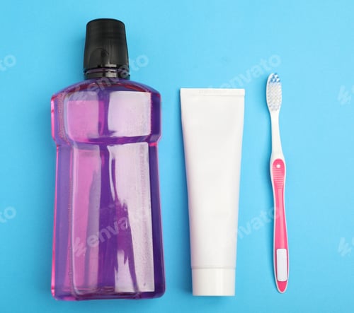 Preview: Mouthwash, toothbrush and toothpaste on light blue background, flat lay