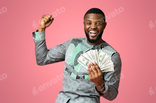 Preview: Happy african american man holding cash on pink