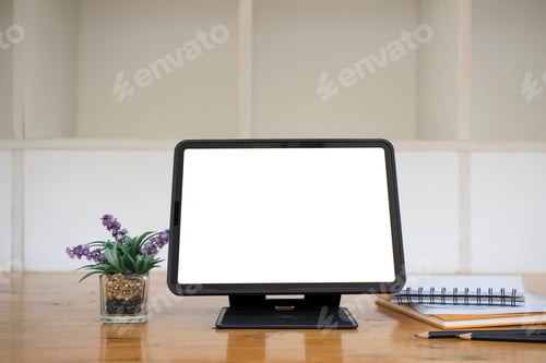 Preview: Computer tablet, houseplant and notebooks on wooden desk.