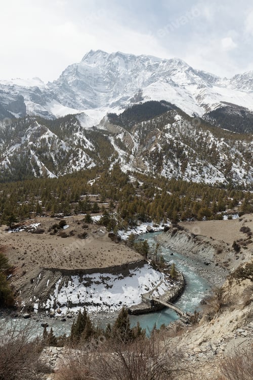 Preview: Scenic view of marshyangdi river making its way through the snow capped mountains in nepal