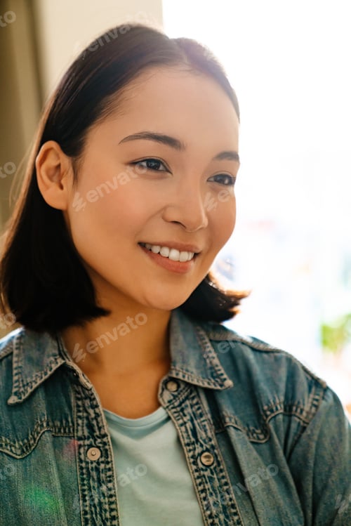 Preview: Young asian woman wearing denim shirt smiling and looking aside