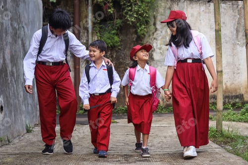 Preview: Group of happy elementary school talking and laughing while going to school together