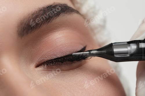 Preview: Young woman undergoing procedure of permanent eye makeup, closeup