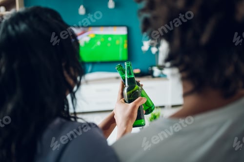 Preview: African american couple drinking beer and watching the football game at home