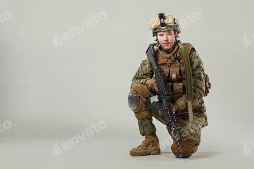 Preview: Soldier kneeling with weapon in training setting during day