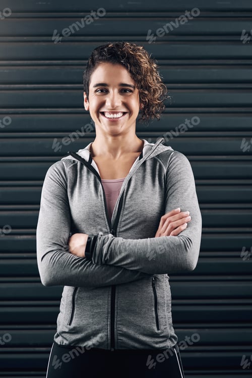 Preview: Portrait of a young beautiful woman folding her arms against a black background