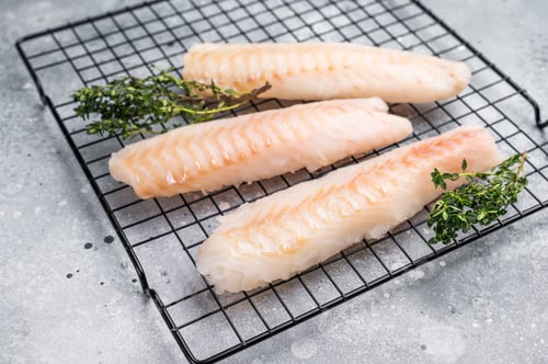 Preview: Fresh raw cod fish fillet, Boneless white fish meat. gray background. top view