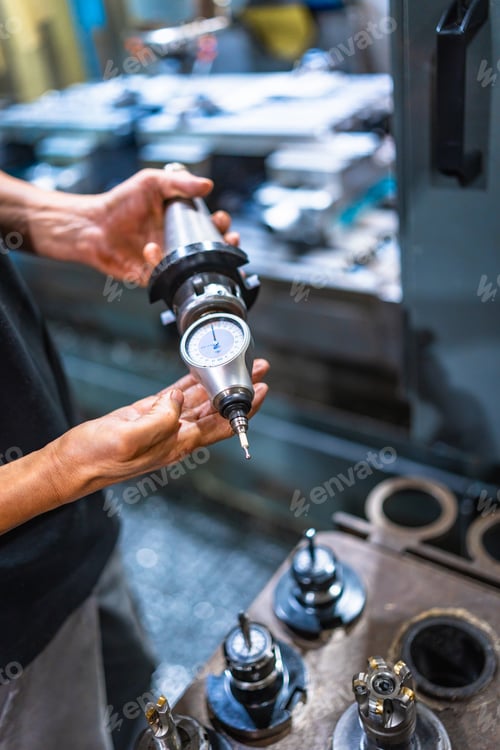 Preview: Technician holding a piece of milling machine working at factory