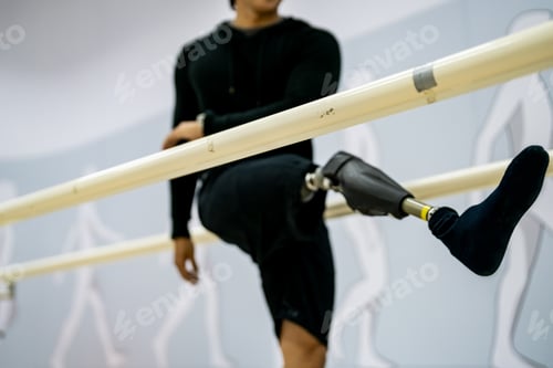 Preview: disabled athlete man, with leg prosthesis working out on sport machine